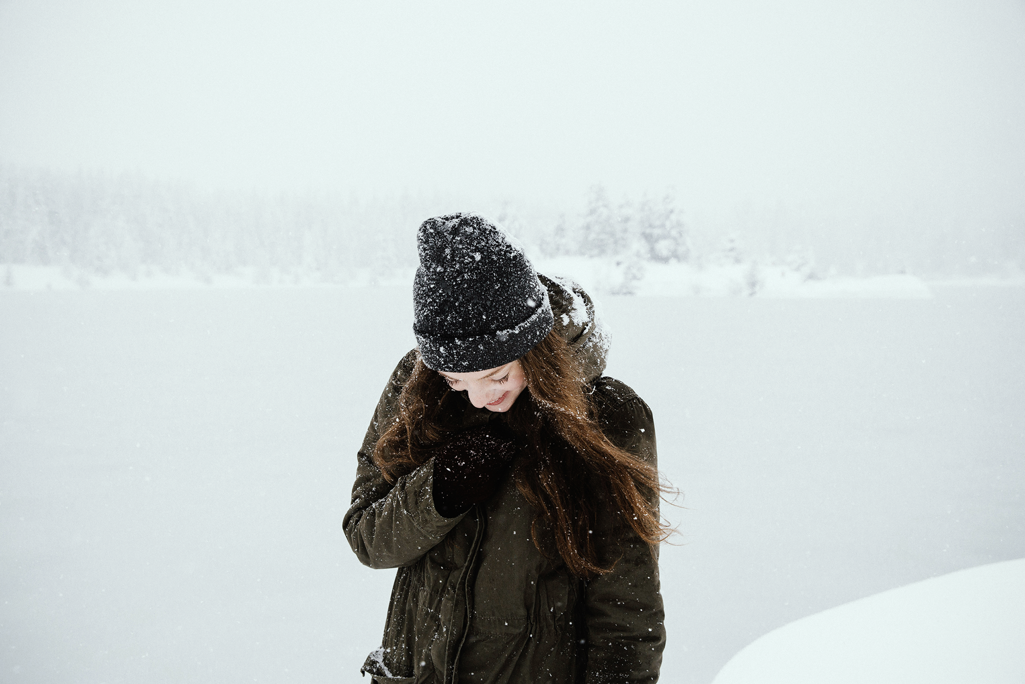 Une femme dans un décor hivernale. Propose qu'elle sait comment se préparer à un voyage dans l'hiver canadien.